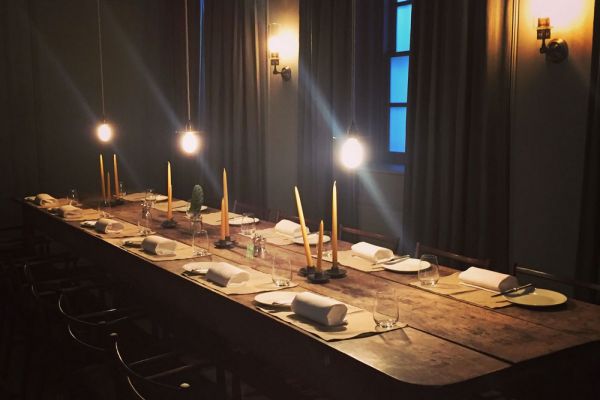 Interni del Thomas Cafe Burberry: tavolo apparecchiato con candele e luci soffuse. Food e fashion.