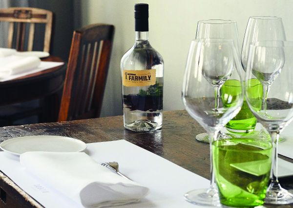 Tavolo imbandito con bottiglia Farmily. Bicchieri da vino e tovagliolo. Flavio Angiolillo barman.