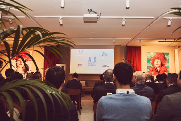 Conferenza food delivery: pubblico assiste a presentazione su dark kitchen e il futuro del fuori casa.
