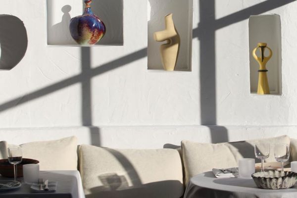 Interni di design ristorante Jaquemus: vasi artistici, tavoli apparecchiati. Food e fashion, binomio di stile.