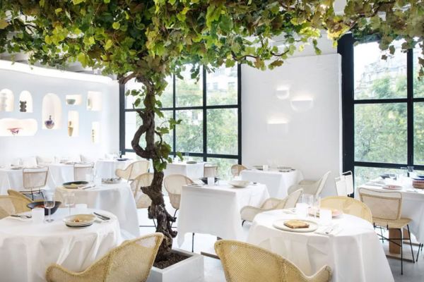 Interno del ristorante Oursin di Jacquemus. Tavoli imbanditi, albero decorativo. Food e fashion.