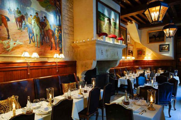 Interni lussuosi del ristorante Ralph's: tavoli imbanditi, divani in pelle, dipinti classici e lampade calde. Food e fashion.