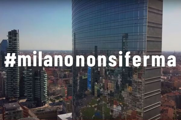 Skyline di Milano con grattacieli moderni e hashtag #milanononsiferma. Architettura urbana e città.