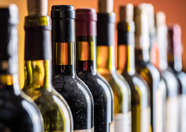 File di bottiglie di vino Tannico. Vendita online e retail fisico di vini pregiati.