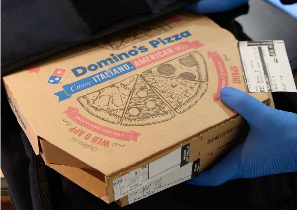 Consegna pizza Domino's contactless. Scatola pizza Domino's con guanti. Pizza a domicilio sicura.