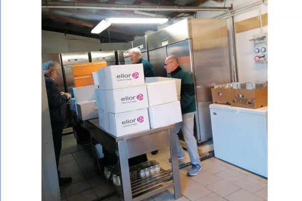 Donazioni Elior: volontari preparano pasti solidali. Ristorazione collettiva e impegno sociale.