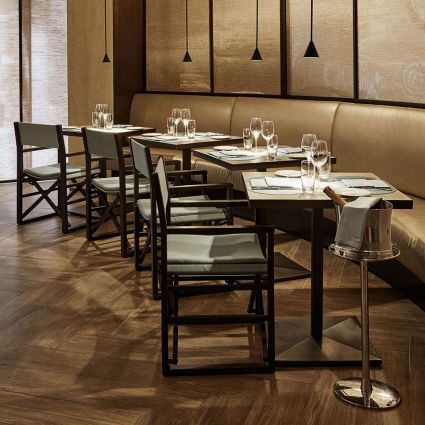 Interni Emporio Armani Ristorante Bologna: tavoli apparecchiati, sedie design, illuminazione elegante. Esperienza di ristorazione di lusso.