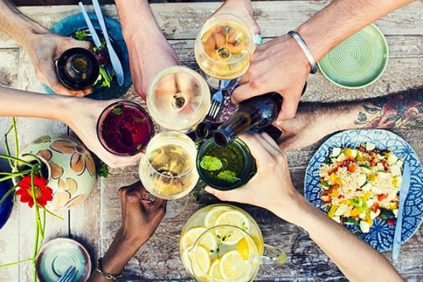 Brindisi e food community: mani con bevande e piatti colorati. Passione per il cibo e convivialità.