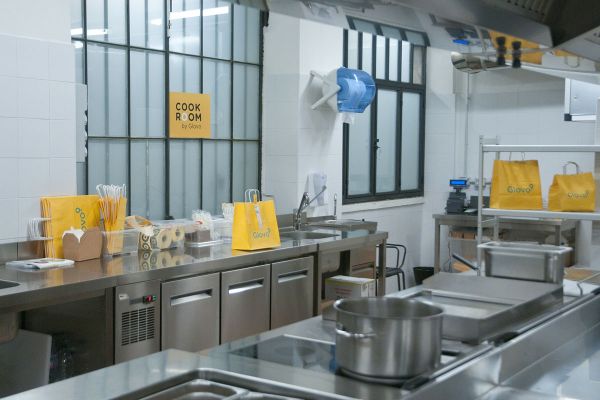 Interno della Cook Room Glovo a Milano. Sacchetti Glovo pronti per la consegna.