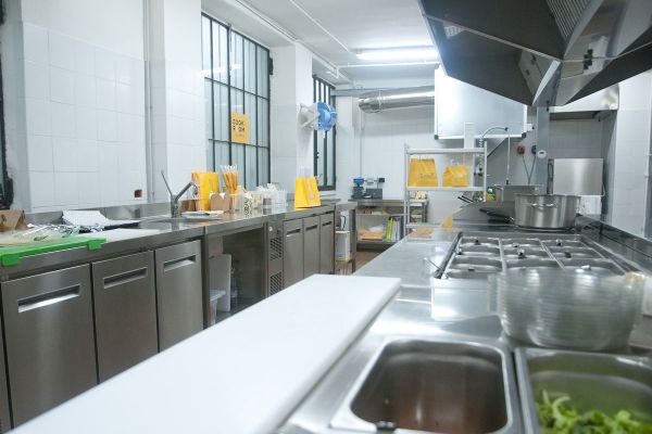 Interno della Cook Room Glovo a Milano. Cucina professionale in acciaio inox.