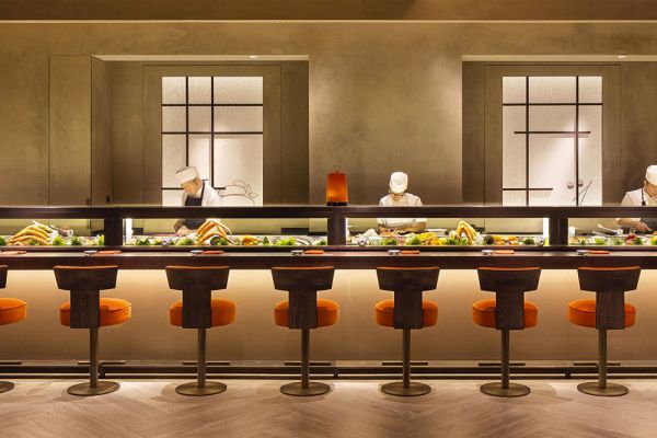 Interni Nobu Milano, ristorante Armani. Sushi chef al lavoro, sedute arancioni.