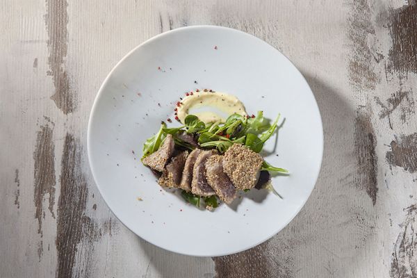Piatto di tonno fresco con sesamo e insalata. Vivo per te: pesce a domicilio.