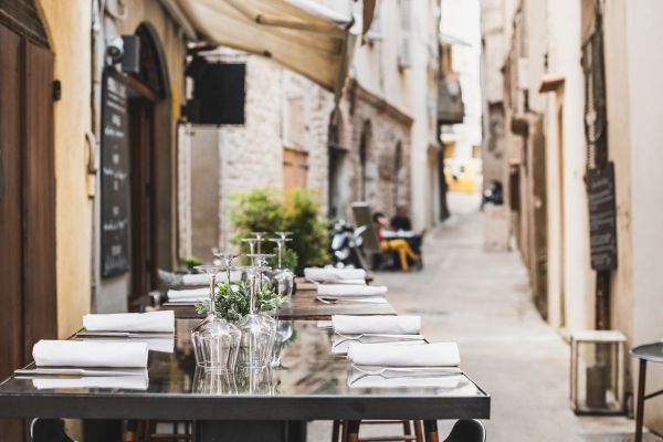Ristorante sotto casa. Tavoli apparecchiati in vicolo suggestivo. Cucina locale e atmosfera accogliente.