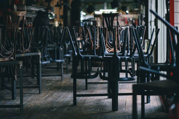 Ristorante chiuso: sedie sui tavoli. Crisi ristorazione, fallimenti brand ristorativi.