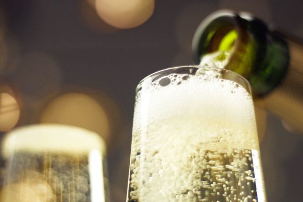 Versando Champagne Lallier. Calice di spumante frizzante. Campari acquisisce Lallier.
