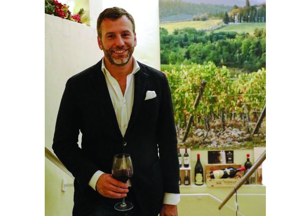 Luca Pizzighella di Signorvino con calice di vino rosso. Ristorazione organizzata e nuove strategie.