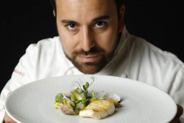 Chef Max Mascia con piatto gourmet. Cucina italiana di alta qualità.