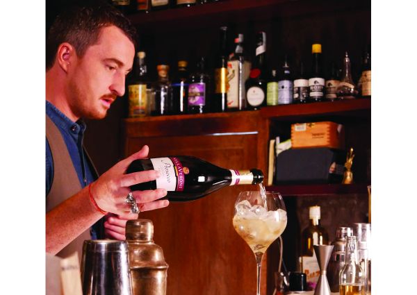 Bartender versa Prosecco. Ristorazione, ripartenza con cocktail e vino. Angiolillo barman.