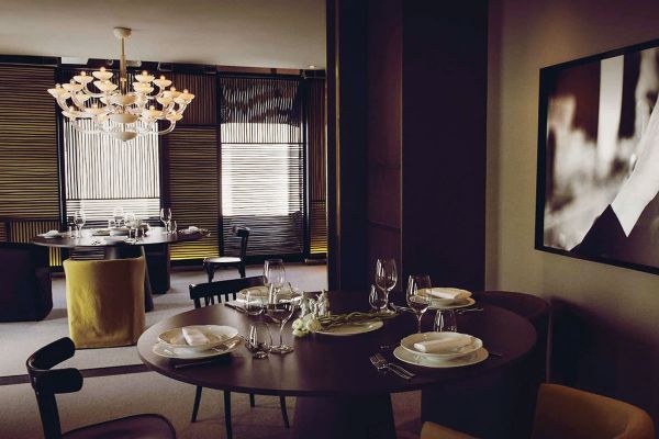 Interno ristorante Filippo La Mantia. Tavoli apparecchiati, lampadario di design. Ristoratori, resilienza.