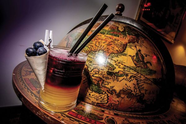 Cocktail vintage su mappamondo antico. Corso barman: un'esperienza unica per bartender del futuro.