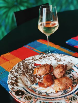 Macelleria Il Mannarino: piatto di carne e calice di vino bianco. Prodotti di alta qualità direttamente a tavola.