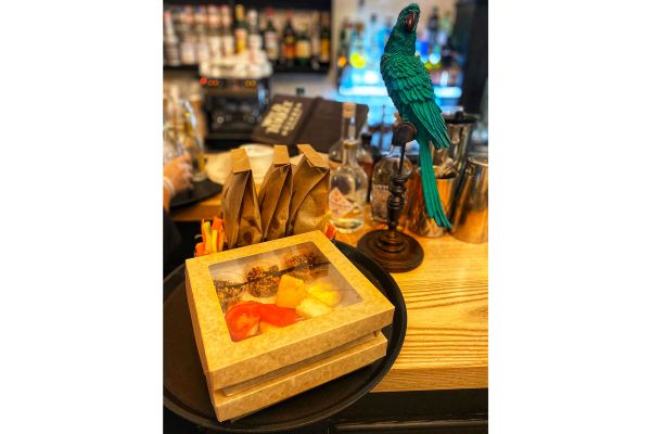 Bar Sparkling American: aperitivo con box take away, cocktail e decoro pappagallo verde.