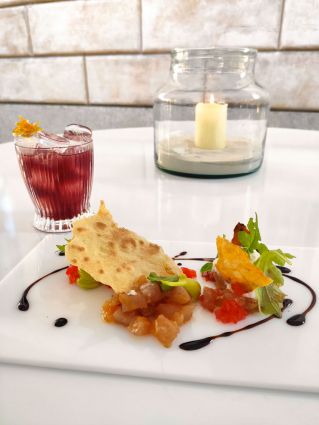 Cocktail estivo e tartare gourmet. Drink rinfrescante e piatto creativo per combattere il caldo.