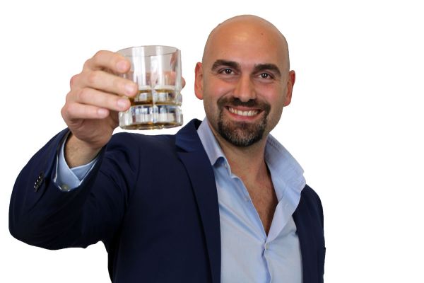 Luca Malizia, esperto gestione bar, con libro su come gestire al meglio un bar. Sorride con bicchiere in mano.