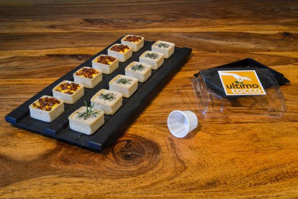 Mini tartine gourmet Ultimo Tocco su tagliere. Food design per delivery, catering e eventi.