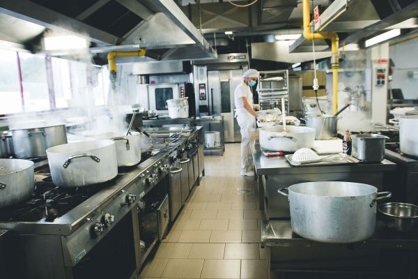 Cucina professionale NutriBees. Pentole fumanti, chef al lavoro. Food delivery healthy e dark kitchen.