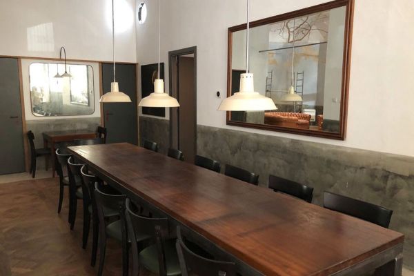 Interni Casadante Roma: tavolo legno, sedie nere, lampade a sospensione. Design semplice e accogliente.