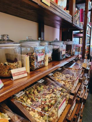 Scaffali Noberasco: barattoli di vetro con frutta secca e legumi misti per food experience e aperitivo.