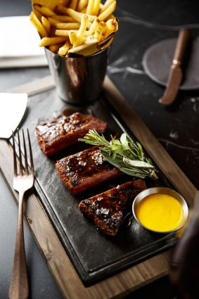 Black Angus steak alla brace con patatine fritte e salsa. Ristorante Al Mercato, steakhouse moderna.