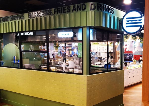 Ristorante BUN: interni moderni. Hamburger, patatine e bevande. Design minimalista e insegna luminosa.