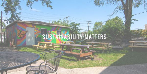 Ristorante etico USA: area esterna con tavoli picnic e murales colorati. Pizza-Plex, sostenibilità.