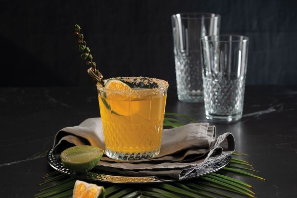 Elegante bicchiere Pasabahce con cocktail. Bicchieri da acqua e decorazioni tropicali.