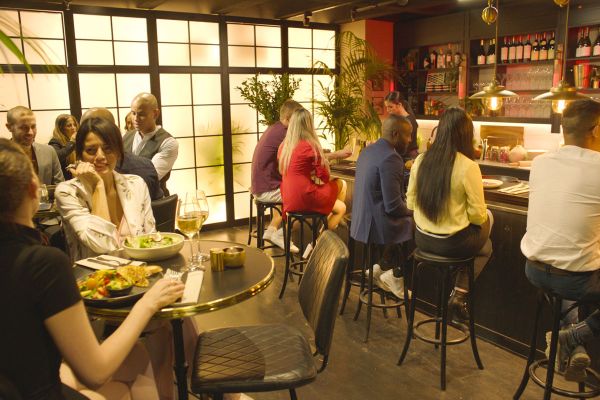 Interni del ristorante The Chicken: persone sedute al bar e ai tavoli, atmosfera conviviale.