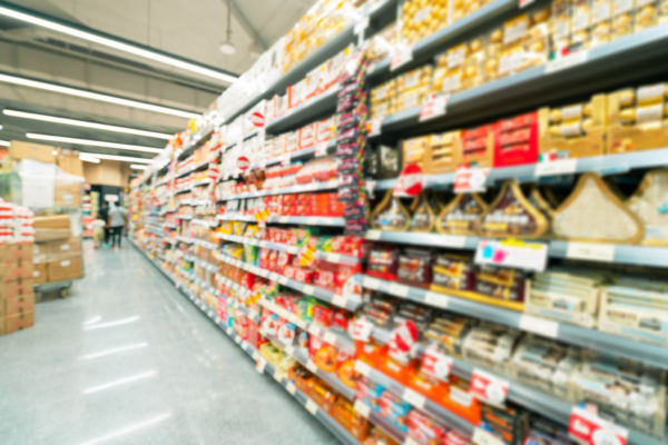 Scaffali di supermercato Migros pieni di prodotti alimentari. Assortimento vario, focus sul cliente.