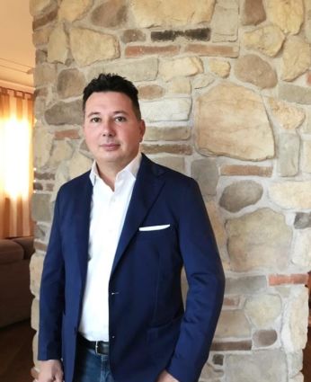 Unicash: Imprenditore in giacca blu. Core business etnico, focus sul mercato.