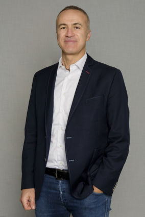 Ritratto di Guerrieri, Metro Italia. Manager sorridente in giacca blu e jeans. Focus su PL, localismo e delivery.