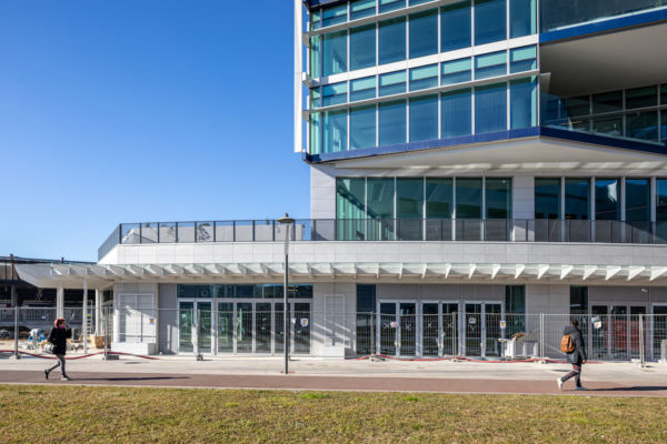 Spark Food District Milano: edificio moderno con vetrate e persone che camminano. Santa Giulia business district.