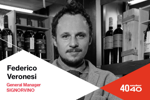 Federico Veronesi, General Manager Signorvino, 40under40. Ritratto in bianco e nero con bottiglie di vino sullo sfondo.