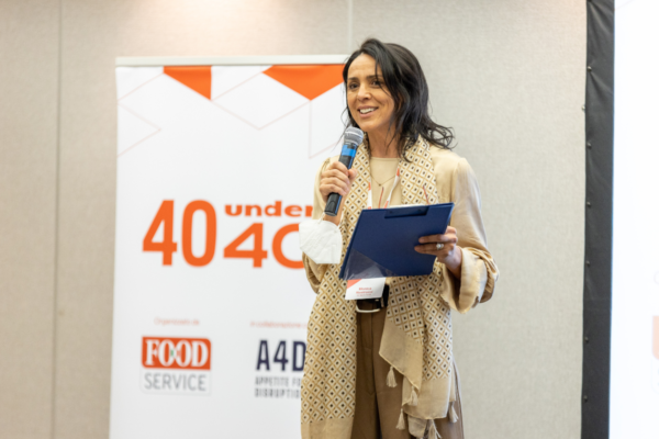 Premiazione 40 Under 40 Milano: donna al microfono. Evento Foodservice per giovani talenti.
