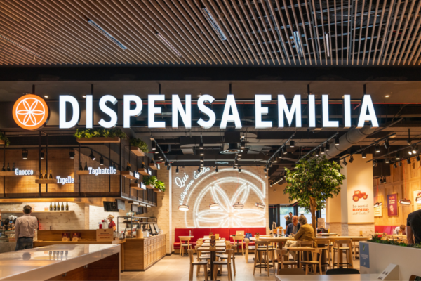 Interni di Dispensa Emilia: ristorante emiliano con tavoli in legno e insegna luminosa. Cucina tradizionale.