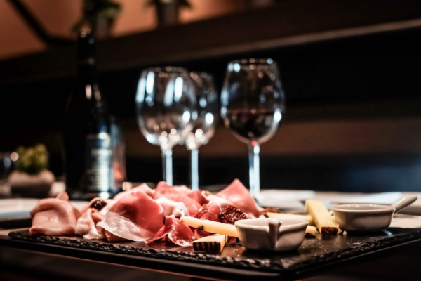 Aperitivo Panino Giusto: tagliere con salumi, formaggi e vino rosso.