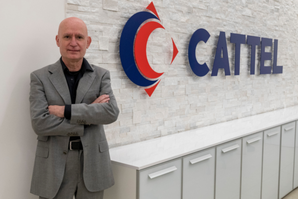 Cattel Horeca: uomo in giacca grigia con logo Cattel. Servizi per ristorazione e hotellerie.