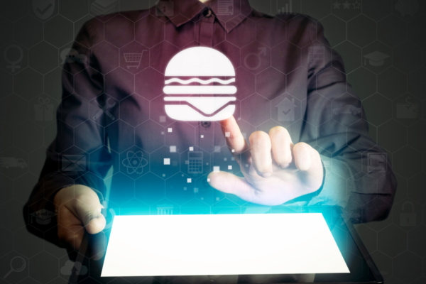 Burger nel metaverso: mano tocca icona hamburger su tablet. Ristoranti virtuali, Wendy's.