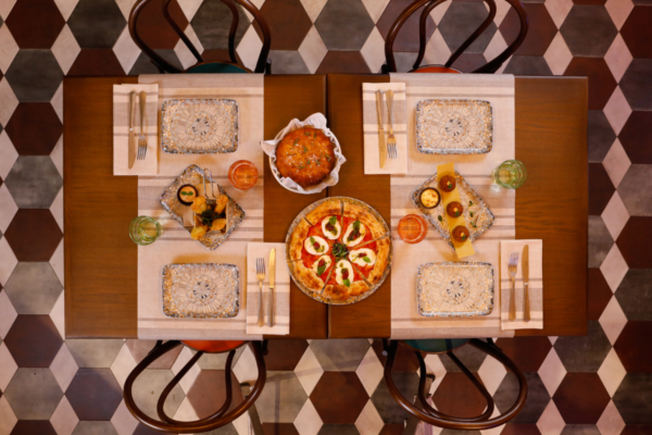 Tavolo imbandito con pizza, focaccia e antipasti. Cucina italiana fast casual, Autogrill Amore.