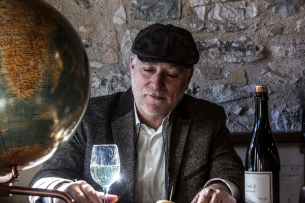 U-label: uomo con mappamondo, bicchiere e bottiglia. Ingredienti etichetta vino.