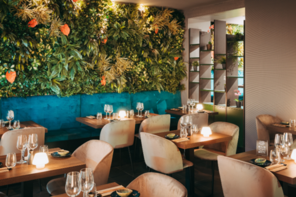 Interno del ristorante Umami Taste Experience: pareti verdi, tavoli apparecchiati, illuminazione soffusa.